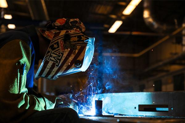 A student welding metal.